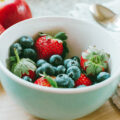 Eine Porzellanschale mit Erdbeeren und Heidelbeeren